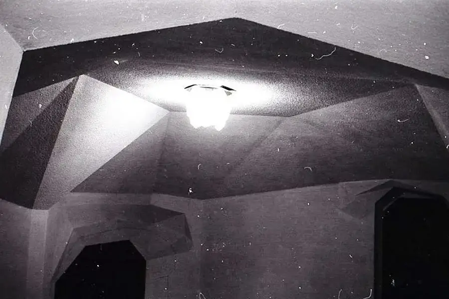 Antesala del salón de actos, con lámpara encendida.