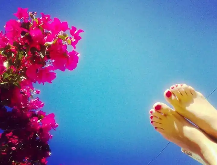 Planta de Santa Rita con fondo de cielo azul, y pies desnudos con uñas pintadas de rojo.