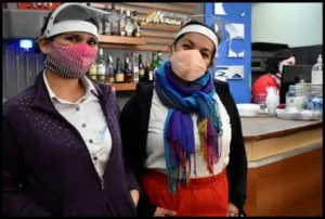 Dos mujeres con barbijo, traban en la pandemia.