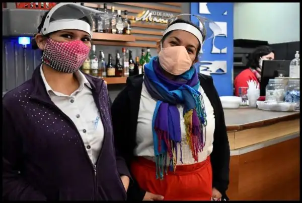 Dos mujeres con barbijo, traban en la pandemia.