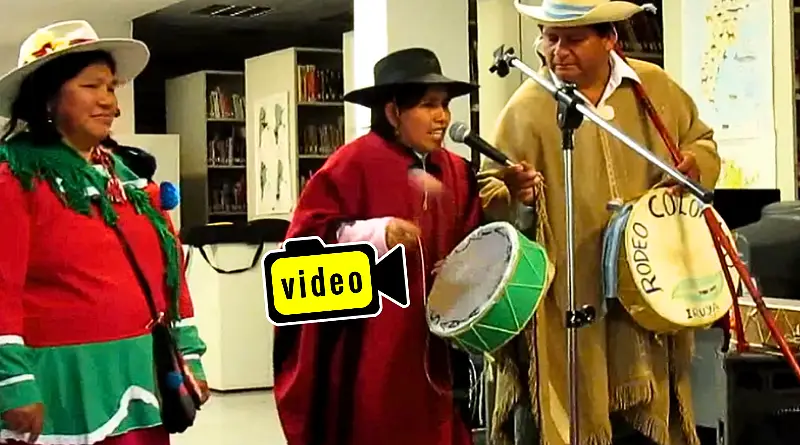 Mónica Romero, vestida con poncho y sombrero, cantando coplas en quechua